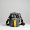 Gray shoulder bag with a yellow tag on a wooden surface and light gray background
