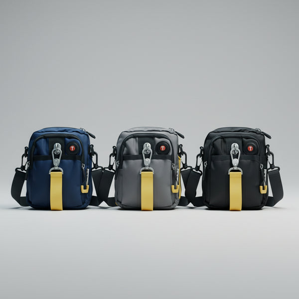 Three black bags with yellow straps on a reflective surface in front of a city skyline at night.