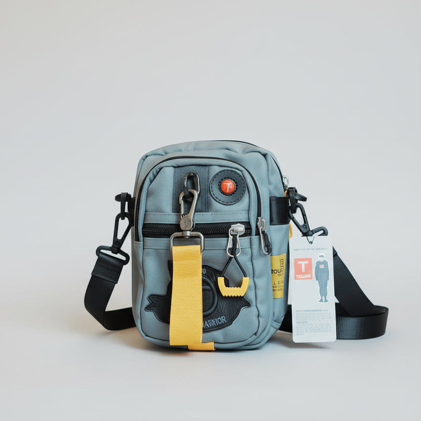 Gray crossbody bag with yellow strap on a reflective surface