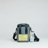 Gray bag with a strap on a reflective surface