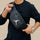 Person wearing a black shirt holding a black waist bag with a logo.

Black belt bag with multiple zipper pockets