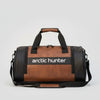 Brown duffel bag with 'arctic hunter' logo in a gym setting